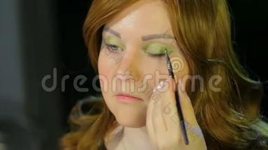 化妆室里的红发女演员做眼妆，绿影准备上台。